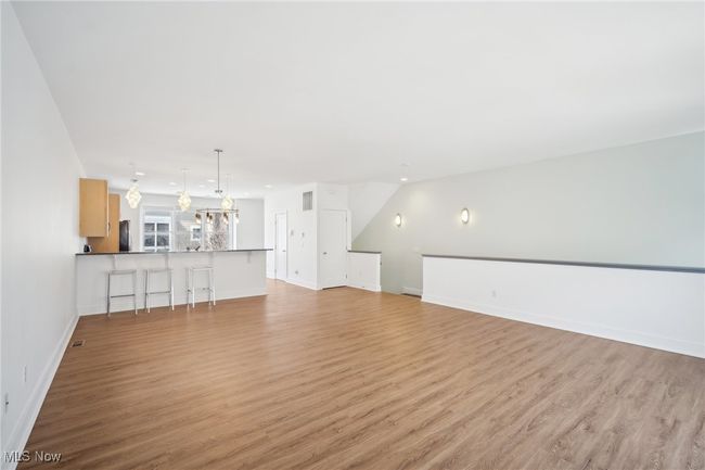 Unfurnished living room with visible vents, baseboards, and light wood-type flooring | Image 7
