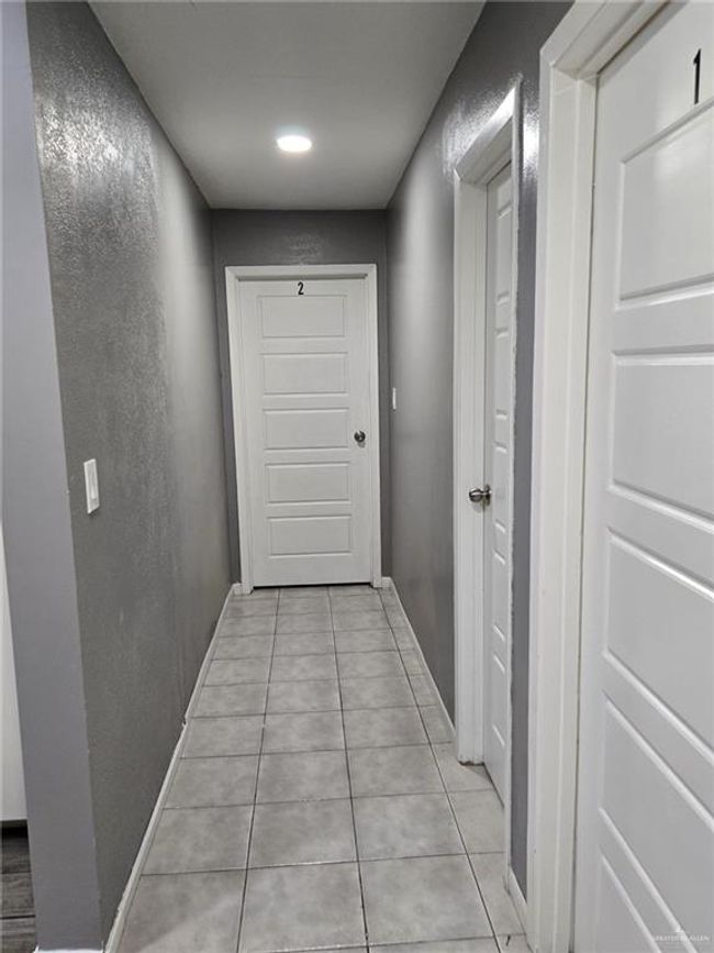Hall with light tile patterned floors, baseboards, and recessed lighting | Image 11