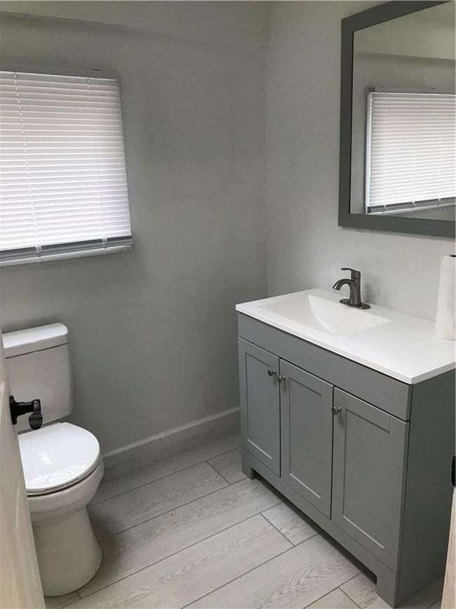 Bathroom featuring wood-type flooring, toilet, and vanity | Image 15
