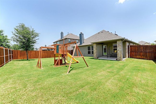 Back of property featuring a playground, a fenced backyard, a patio, and a chimney | Image 4