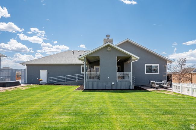 Back of house with a chimney, a fenced backyard, a patio, and stucco siding | Image 97