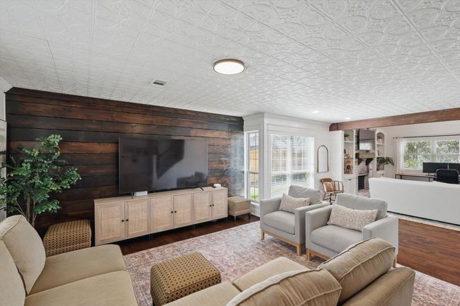 Living area featuring an ornate ceiling, dark wood finished floors, and wood walls | Image 4