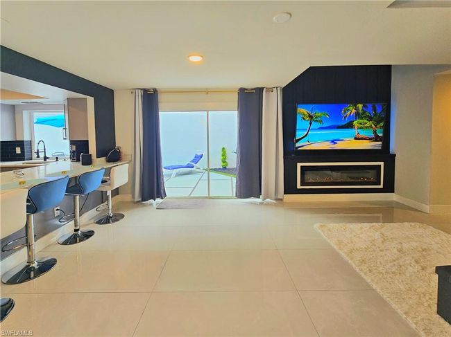 Tiled living area with recessed lighting, a glass covered fireplace, plenty of natural light, and baseboards | Image 11