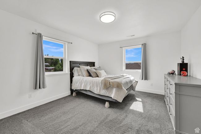 Bedroom featuring multiple windows and dark colored carpet | Image 36