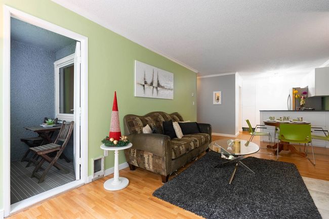 Living room with a textured ceiling, wood finished floors, ornamental molding, and baseboards | Image 5