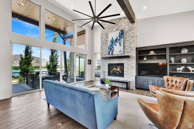 Living area with double sliding doors opening to oversized deck with water view. | Image 16