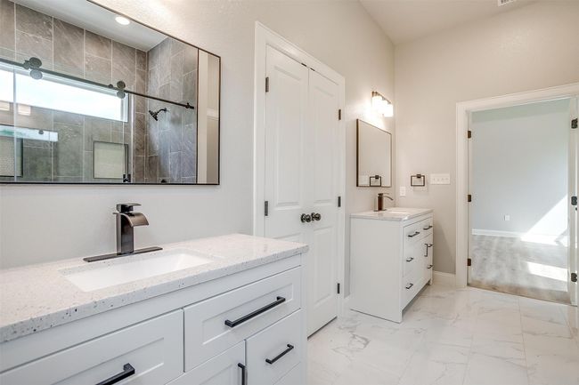 Bathroom featuring a sink, two vanities, a shower stall, and marble finish floor | Image 20