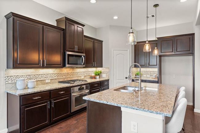Stainless steel appliances, gas cooktop, high-arc pull-down faucet, reverse osmosis drinking water and instant hot water at the kitchen sink blends style and function | Image 14