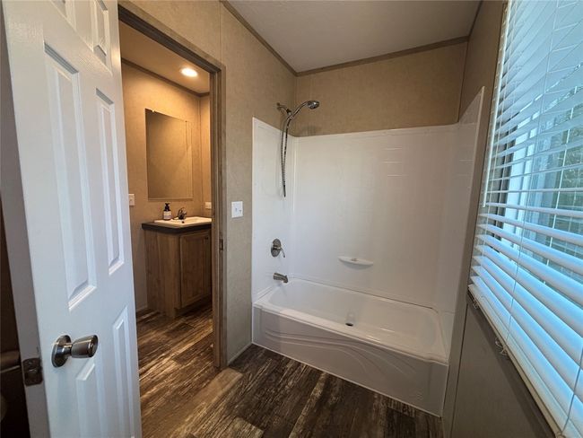 Full bath with ornamental molding, shower / bathing tub combination, wood finished floors, and vanity | Image 15