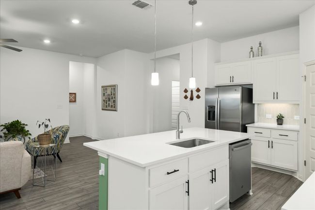 Kitchen featuring wood finished floors, visible vents, a sink, appliances with stainless steel finishes, and decorative light fixtures | Image 20