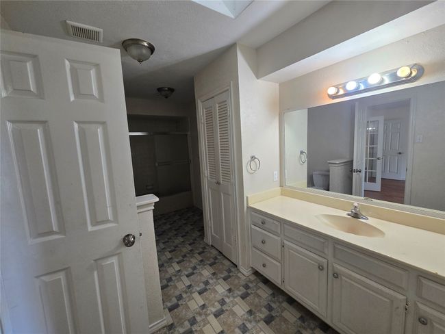 Full bath featuring vanity, a closet, tile patterned floors, and a skylight | Image 14