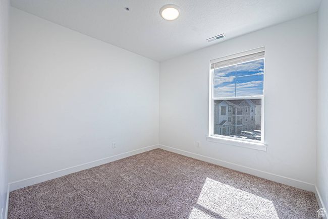 Carpeted spare room featuring visible vents, baseboards, and a textured ceiling | Image 13