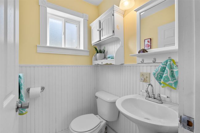 Half bath with a wainscoted wall, a sink, and toilet | Image 12