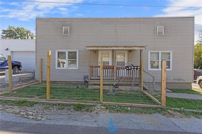 View of front of home featuring a garage, a front yard, and covered porch | Image 1