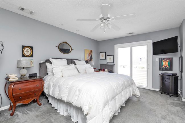 Carpeted bedroom with visible vents, access to exterior, ceiling fan, and baseboards | Image 9