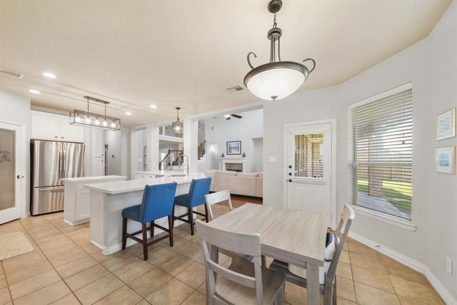 A glass door with blinds opens to the covered patio & backyard. Nearby is the home's utility room. | Image 20
