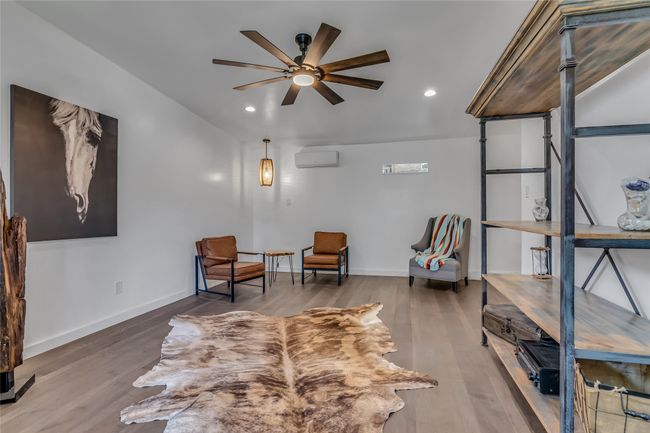 Guest room featuring a ceiling fan, a wall mounted air conditioner, wood finished floors, vaulted ceiling, and recessed lighting | Image 25