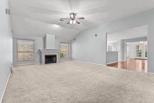 Unfurnished living room with french doors, carpet, a ceiling fan, baseboards, and visible vents | Image 9