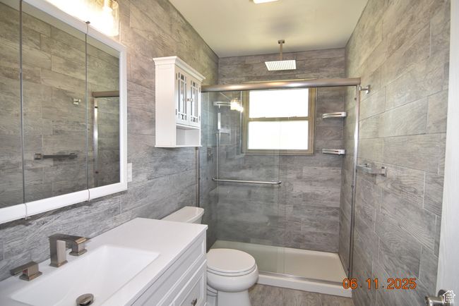 Bathroom with tile walls, a shower stall, and vanity | Image 36
