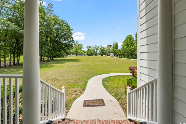 View of green lawn with covered porch | Image 5