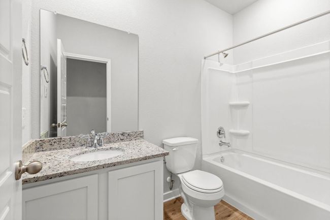Bathroom featuring vanity, shower / tub combination, wood finished floors, and toilet | Image 26