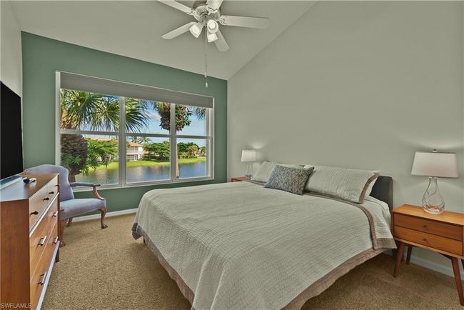 Carpeted bedroom featuring ceiling fan, lofted ceiling, and a water view | Image 9