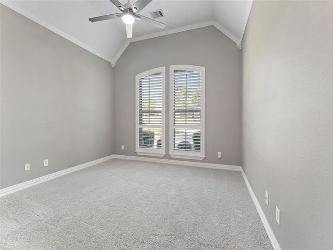 Spare room featuring a ceiling fan, carpet, vaulted ceiling, and crown molding | Image 25