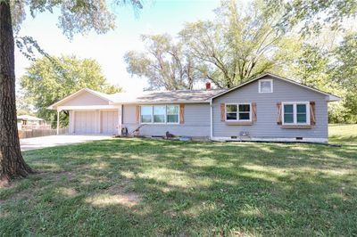 Ranch-style house with a garage and a front lawn | Image 1