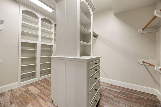 Ensuite closet has built-in shelving and drawers for organization. | Image 24