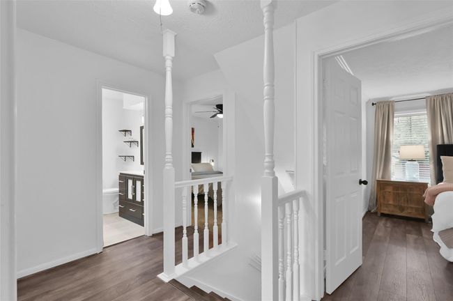 At the top of the stairs, you have access to all four Bedrooms and two full Bathrooms. The upstairs Hallway also has laminate wood flooring. | Image 13