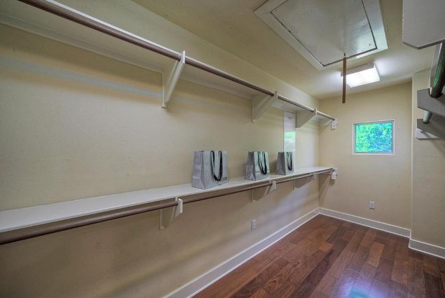 Walk in closet featuring attic access and wood floors | Image 26