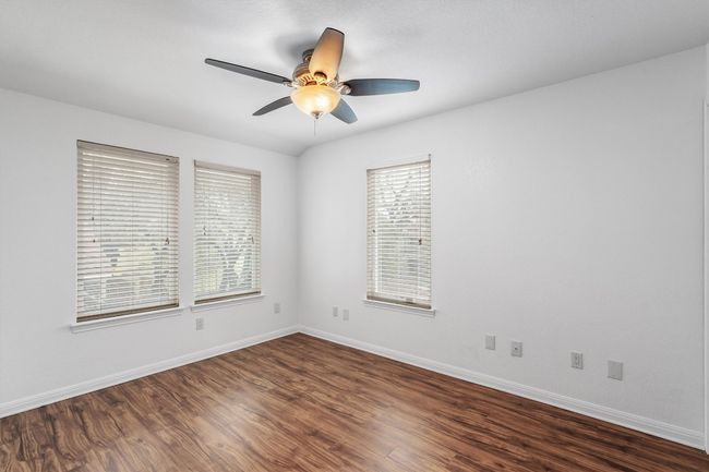 Empty room with baseboards, a ceiling fan, and dark wood-style flooring | Image 17