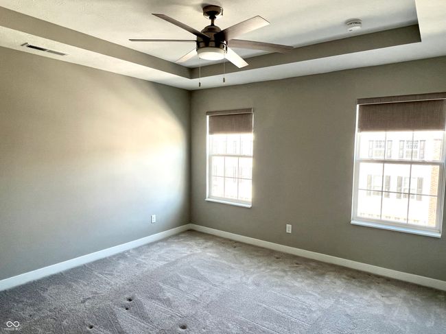 Primary bedroom with tray ceiling, custom blinds, ceiling fan & customized walk-in closet | Image 39