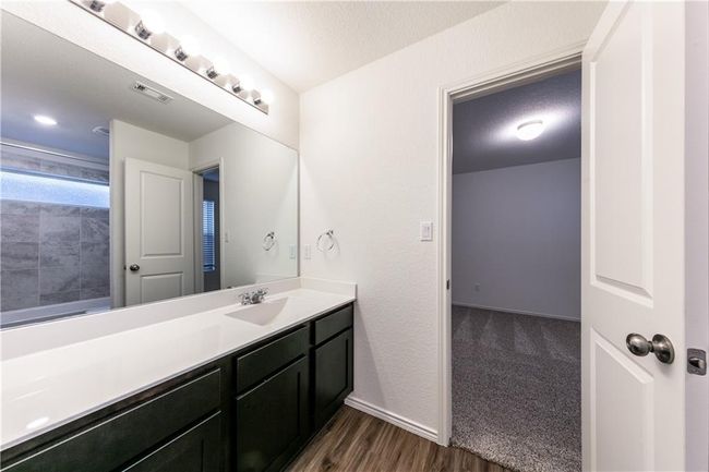 Bathroom with vanity, wood finished floors, and a shower | Image 13