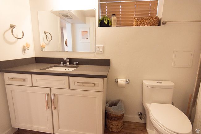 Bathroom featuring toilet, vanity, wood finished floors, and baseboards | Image 15