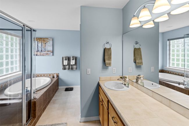 Full bathroom with double vanity, a garden tub, a shower stall, and tile patterned flooring | Image 46