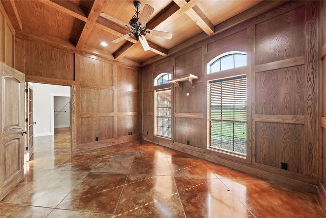Unfurnished room with wooden ceiling with exposed beams, coffered ceiling, wood walls, ceiling fan, and baseboards | Image 15