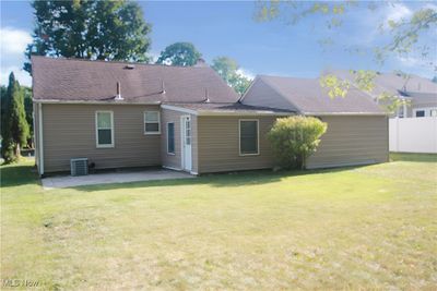 Rear view of house with a patio area, a yard, and cooling unit | Image 2