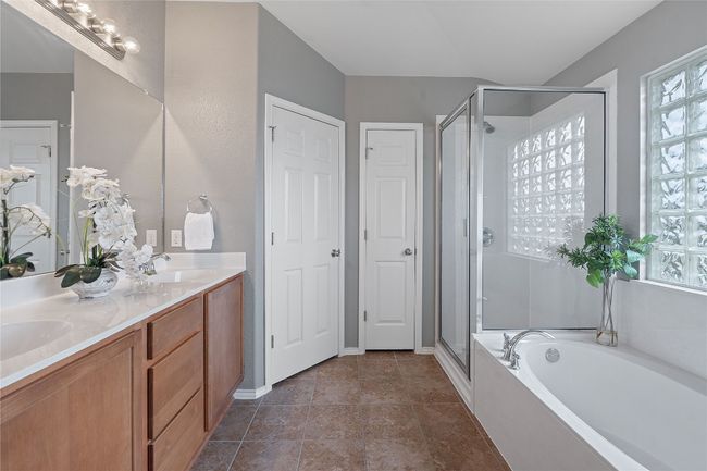 Bathroom with a stall shower, a garden tub, double vanity, and healthy amount of natural light | Image 30