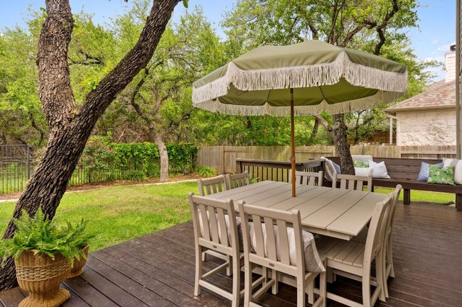 The backyard offers complete privacy with no neighbors behind—just a backdrop of mature oak trees, flowering vines, and room to relax or play. | Image 30
