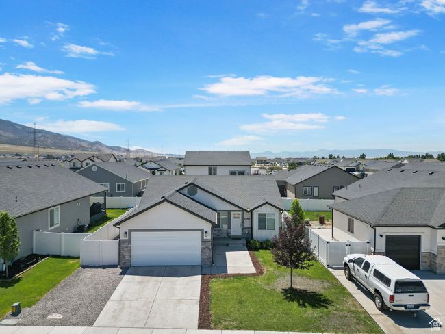 View of front facade with a residential view, a garage, stone siding, and concrete driveway | Image 31