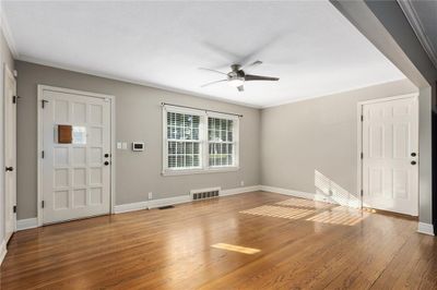 Living room with glowing hardwoods and vintage wood door | Image 3