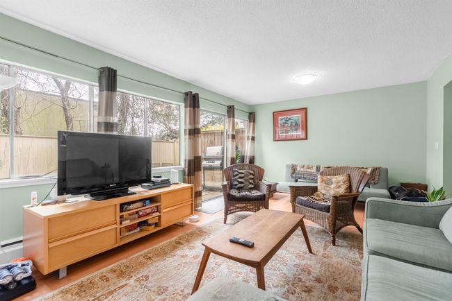 Living area with light wood finished floors and a textured ceiling | Image 4