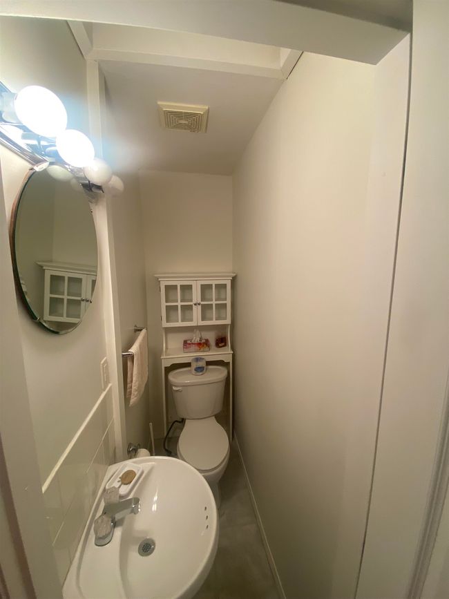 Half bathroom featuring toilet, a sink, and visible vents | Image 14