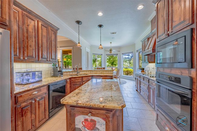 Kitchen featuring plenty of natural light, tasteful backsplash, and black appliances | Image 20