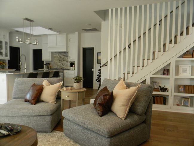 Living room adjacent to open kitchen and stairway features wood flooring | Image 6