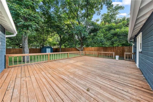 This deck will be removed and rebuilt as either a concrete patio or raised redwood deck stained to match the fence. | Image 36