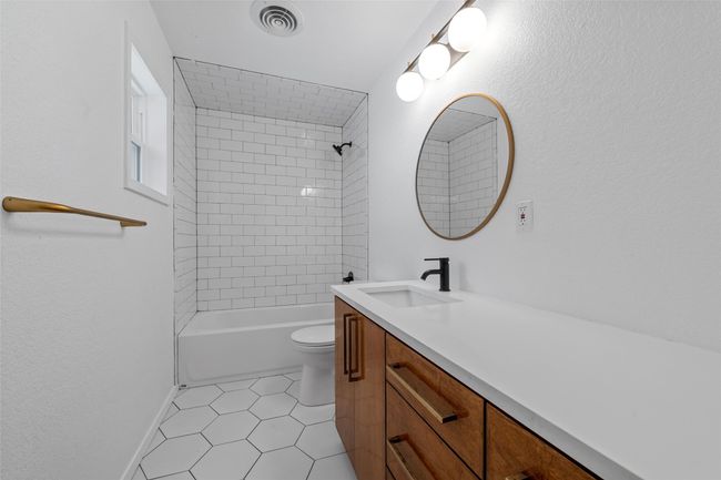Bathroom featuring tile patterned flooring, vanity, toilet, shower combination, and baseboards | Image 27