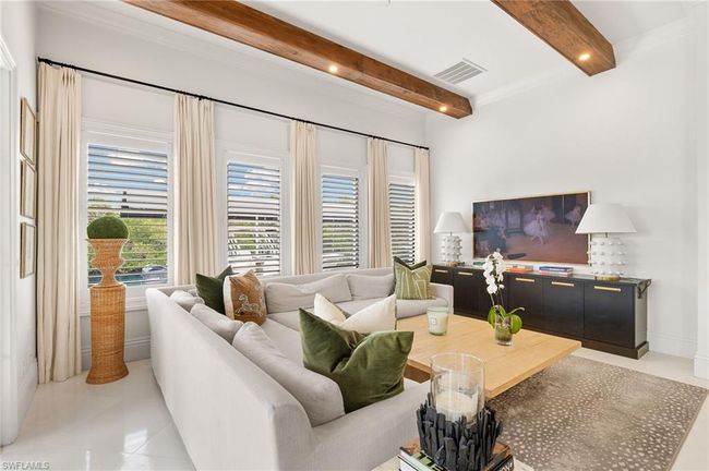 Living area featuring beam ceiling, light tile patterned flooring, and visible vents | Image 8