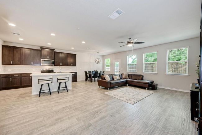 Living area featuring healthy amount of natural light, ceiling fan, light wood-style floors, and recessed lighting | Image 6